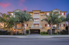 Sylmar apartment for rent - a street view of an apartment building with palm trees at Dronfield Astoria, 13140 Dronfield Ave