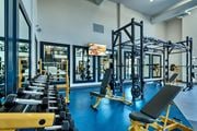 Glendale apartment for rent - a gym with cardio equipment and weights on a blue floor at Cuvee, Glendale, AZ
