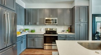 Elevation san tan's modern kitchen with a stainless steel refrigerator and a stove top oven.