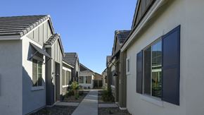 Chandler apartment for rent - a row of houses with walkways between them and a blue sky at Village of Chandler Apartments, Chandler, Arizona