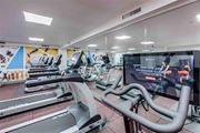 Seattle apartment for rent - A gym with treadmills and a screen showing a live class.
