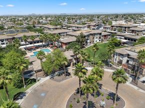 Peoria apartment for rent - A view of a residential area with a swimming pool and palm trees.