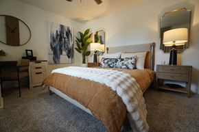 Sun City apartment for rent - A bedroom with a large bed and a painting on the wall.