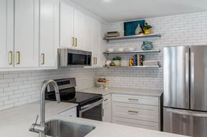 Houston apartment for rent - a white kitchen with stainless steel appliances and white cabinets