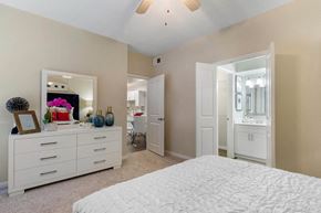 Houston apartment for rent - a white bedroom with a large bed and a mirror