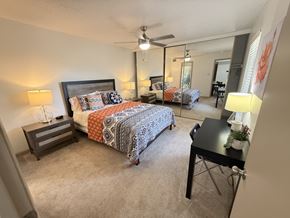 Carrollton apartment for rent - A bedroom with a bed, desk, and mirror.
