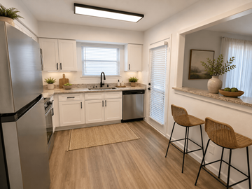 Plano apartment for rent - A kitchen with white cabinets and a stainless steel refrigerator.