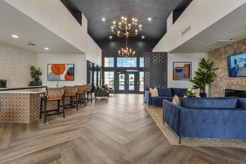 Sun City apartment for rent - A modern living room with a blue couch and a chandelier.