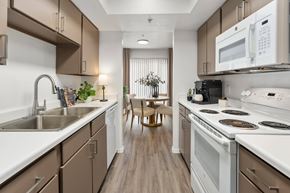 Sun City apartment for rent - A kitchen with brown cabinets and white appliances.