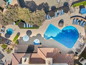 Tucson apartment for rent - A large swimming pool surrounded by a tiled patio and a small tree.