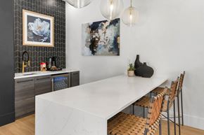 Tucson apartment for rent - A modern kitchen with a long white table and chairs.
