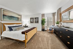 Tucson apartment for rent - A bedroom with a large bed and a painting on the wall.