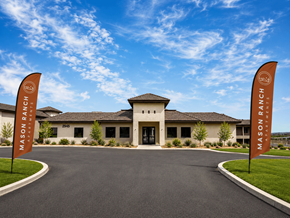 Tucson apartment for rent - The entrance to Mason Ranch Resort with two flags on either side.