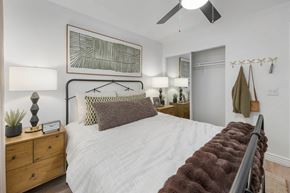 Tucson apartment for rent - A bedroom with a white bed and a brown headboard.