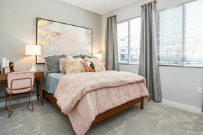 Henderson apartment for rent - A bedroom with a bed, desk, chair, and a large painting on the wall.
