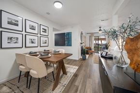 Plano apartment for rent - A dining room with a table set for four and a long hallway.