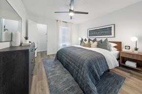 Plano apartment for rent - A bedroom with a large bed and a ceiling fan.