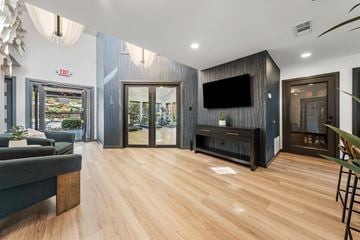 Plano apartment for rent - A modern living room with a grey couch and a wooden floor.