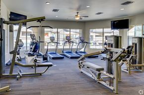 Tucson apartment for rent - A gym with treadmills, elliptical machines, and weight machines.