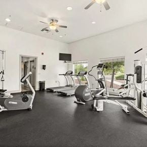Sierra Vista apartment for rent - A spacious gym with treadmills, elliptical machines, and a fan.