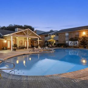 Katy apartment for rent - A swimming pool in a backyard with a house in the background.