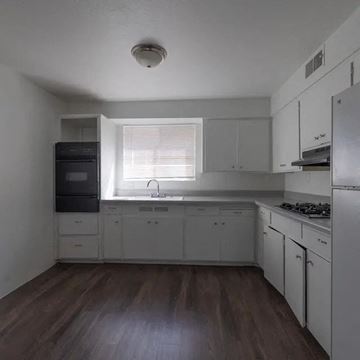 Scottsdale apartment for rent - A kitchen with white cabinets and a black fridge.