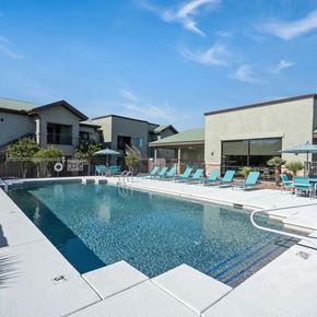 Tucson apartment for rent - A swimming pool with blue water and lounge chairs.