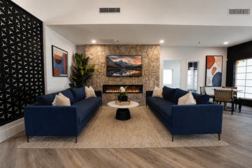 Sun City apartment for rent - A living room with two blue couches and a fireplace.