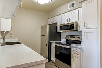 Phoenix apartment for rent - A kitchen with a stainless steel refrigerator, microwave, and oven.