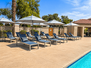 Sun City apartment for rent - A row of lounge chairs are arranged in a row by a pool.