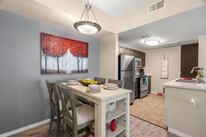 Tucson apartment for rent - A kitchen with a table and chairs and a painting on the wall.