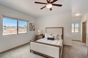 Tucson apartment for rent - A bedroom with a large bed and a ceiling fan.