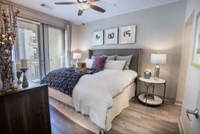 Scottsdale apartment for rent - A bedroom with a bed, a side table, and a ceiling fan.