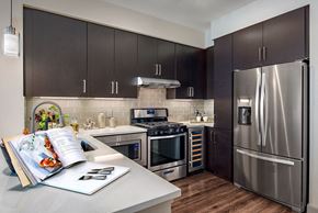 Scottsdale apartment for rent - A modern kitchen with dark brown cabinets and stainless steel appliances.