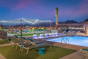 Scottsdale apartment for rent - A pool area with lounge chairs and a palm tree.