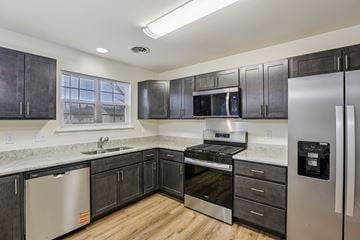 Mechanicsburg apartment for rent - A kitchen with dark wood cabinets and stainless steel appliances.