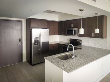 Miami apartment for rent - a kitchen with granite counter tops and a stainless steel refrigerator