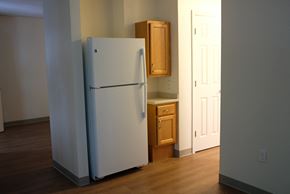 Bedford apartment for rent - an empty kitchen with a white refrigerator and wooden floors