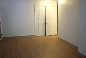 Bedford apartment for rent - an empty living room with two doors and a wood floor