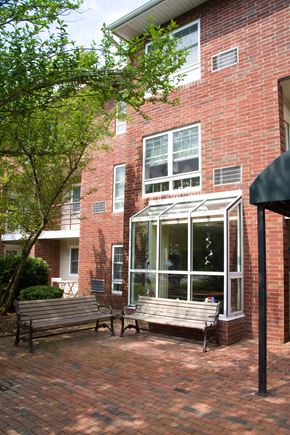 Randolph apartment for rent - two benches in front of a brick building with a window
