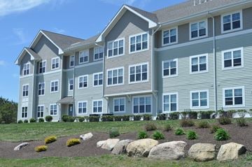 Bourne apartment for rent - a large apartment building with large rocks in front of it