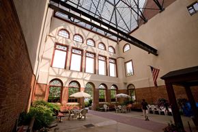 Pittsfield apartment for rent - a large building with a glass ceiling and a courtyard with tables and chairs