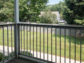 Hyannis apartment for rent - A metal railing overlooks a green lawn.