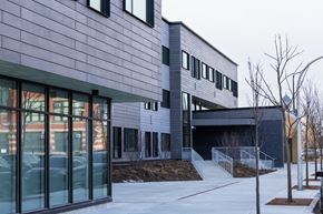 Chicago apartment for rent - A modern building with a grey exterior and a glass entrance.