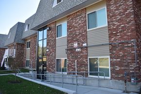 Cambridge townhouse for rent - A red brick building with a grey roof and a metal railing in front.