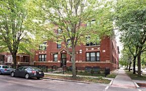 Chicago apartment for rent - a red brick building with cars parked in front of it