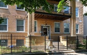 Chicago apartment for rent - a brick house with a black fence in front of it