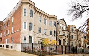 Chicago apartment for rent - a large brick building with a fence in front of it
