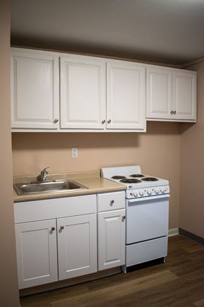 Salem apartment for rent - an empty kitchen with white cabinets and a stove and sink