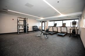 Chicago apartment for rent - A gym with a variety of equipment including treadmills, weights, and a bench press.
